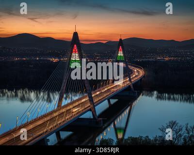 Budapest, Ungarn - aus der Vogelperspektive der Megyeri-Brücke, beleuchtet in festlichen ungarischen Nationalfarben zu Ehren der Revolution und des Krieges vom 15. März 1848 Stockfoto