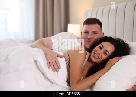 Nettes Paar, das zu Hause im Bett liegt Stockfoto