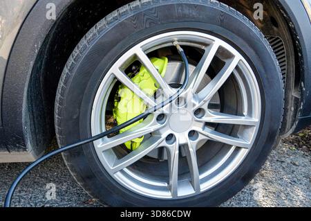 Nahaufnahme eines Fahrzeugrads mit einem Elektrokabel. Stockfoto