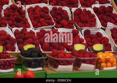 Заголовок Himbeeren und Brombeeren auf einem Marktstand. Stockfoto