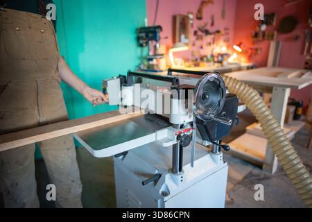 Erfahrener Handwerker, der mit Holz an Hobeldickengelenken arbeitet, Möbelmaterialien vorbereitet Stockfoto