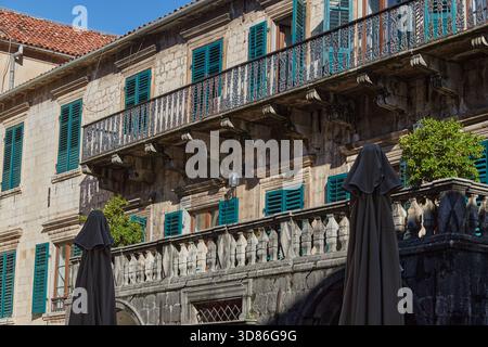 Historisches Steingebäude mit grünen Fensterläden auf einem Platz in der Altstadt von Kotor, Montenegro Stockfoto