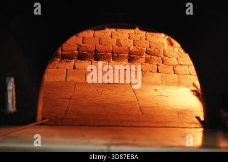 Holzofen glühend in rustikaler Umgebung Stockfoto