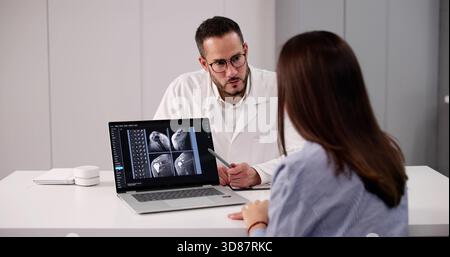 Arzt erklärt dem Patienten in der Klinik mit Computer die Schulterröntgenaufnahme. Chirurgenberatung Stockfoto