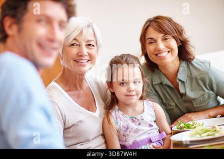 Essen, Porträt und Lächeln mit der Familie beim Mittagessen für Bonding, Ernährung und Thanksgiving. Großmutter, Mädchen und geselliges Treffen mit Dad beim Essen Stockfoto