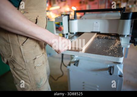 Erfahrener Handwerker, der mit Holz an Hobeldickengelenken arbeitet, Möbelmaterialien vorbereitet Stockfoto