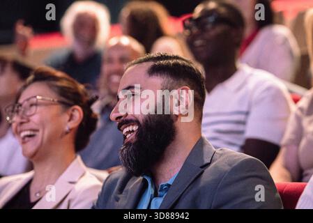 Glücklicher bärtiger Mann, der das Bühnenspiel im Theater genießt Stockfoto