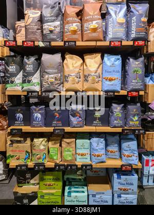 Kiel, Deutschland - 24. November 2025: Tchibo Kaffeebeutel und -Pakete sind in Holzregalen für Supermärkte ordentlich angeordnet und bieten eine vielfältige Auswahl an Einzelhandelsgeschäften Stockfoto