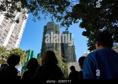 Zuschauer trauern, während sie zum feuergeschädigten Wang Fuk Court blicken, einer Katastrophe, die am 26-28 2025. November über 100 Menschenleben forderte. Stockfoto