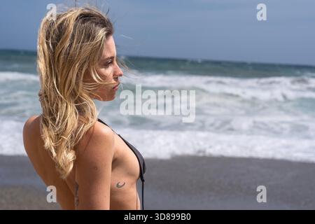 Das wunderschöne venezolanische, blonde Bikinimodell genießt die Schönheit des Alboran Sea und genießt im Urlaub ein herrliches Strandglück. || Modell freigegeben Stockfoto