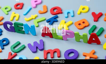 Bunte Buchstaben aus Holz, die den Satz „Gen ALPHA“ bilden, symbolisieren Generation Alpha. Moderne Kindheit, digitale Einheimische, frühes Lernen Stockfoto