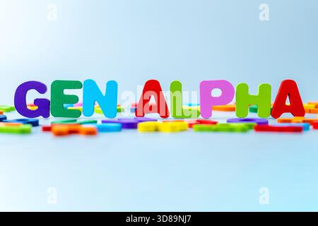 Bunte Buchstaben aus Holz, die den Satz „Gen ALPHA“ bilden, symbolisieren Generation Alpha. Moderne Kindheit, digitale Einheimische, frühes Lernen Stockfoto