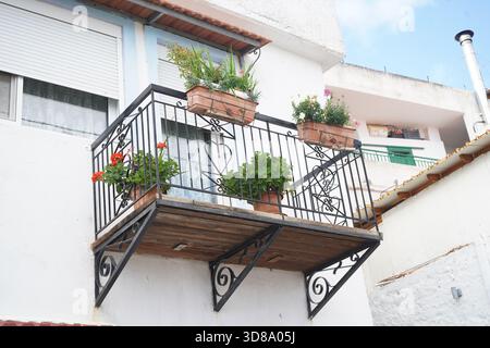 Traditioneller griechischer Dorfbalkon in Melampes, Kreta, mit schmiedeeisernem Geländer und Holzsockel, dekoriert mit Blumenkästen Stockfoto