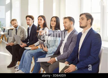 Gruppe junger, selbstbewusster Geschäftsleute, die im Büro über Jobprojekte oder Startups diskutieren Stockfoto