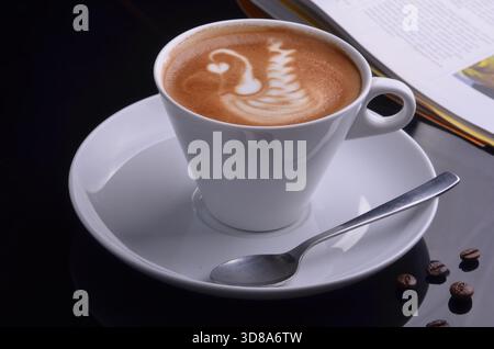 Eine Tasse Kaffee Latte und Buch auf einem Tisch Stockfoto