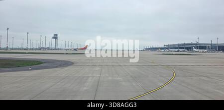 Doloman, Türkei - 25. April 2025: Das Flugzeug parkt auf der Start- und Landebahn eines modernen Flughafens unter bewölktem Himmel. Stockfoto