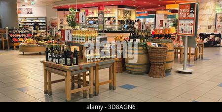 Berlin, Deutschland - 19. September 2025: Weinflaschen auf Tischen mit Holzfässern und frischen Produkten in der Nähe. Stockfoto
