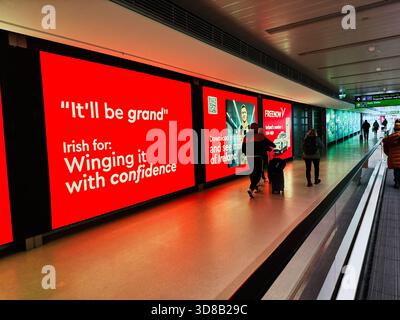 Dublin, Irland - 21. Oktober 2025: Geschäftiges Flughafenterminal in Dublin mit auffälligen roten Anzeigen, Laufsteg und Reisenden. Stockfoto