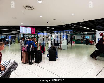 Dublin, Irland - 21. Oktober 2025: Geschäftiges Flughafenterminal in Dublin mit Reisenden, Gepäck und Serviceschalter. Stockfoto