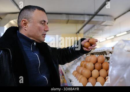 Kunde wählt Eier im Supermarkt, Einkaufen von Lebensmitteln im Kühlbereich. Hochwertige Fotos Stockfoto