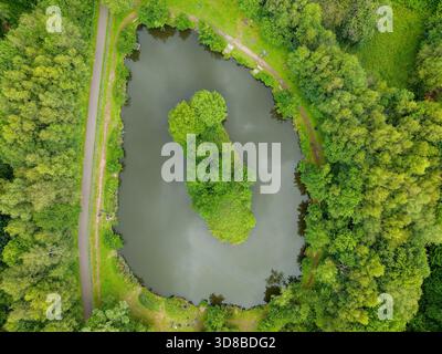 Wunderschöne Naturlandschaft mit einem kleinen See und einer Insel in einem walisischen Landpark Stockfoto