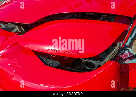 Detail der Markenbeschriftung auf der Scheinwerferabdeckung eines kaputten roten Pontiac Firebird Stockfoto