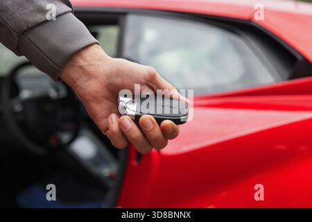 Slowenien, Ljubljana - 9. Oktober 2025: Lamborghini Huracan STO-Schlüssel wird von einer Person in der Nähe der Autotür im Händlerbetrieb gehalten Stockfoto