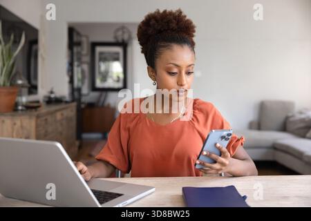 Fokussierte beschäftigte afroamerikanische professionelle Frau, die von zu Hause aus arbeitet Stockfoto