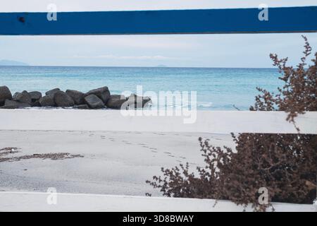 Mittelmeer im Winter von einem sizilianischen Strand mit einem Sträucher im Vordergrund Stockfoto