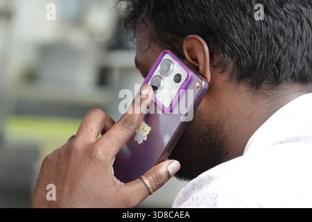 Singapur, 9. September 2025 männlicher Tourist auf seinem Smartphone an einem Restauranttisch in Little India, Singapur Stockfoto