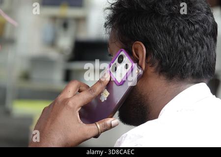 Singapur, 9. September 2025 männlicher Tourist auf seinem Smartphone an einem Restauranttisch in Little India, Singapur Stockfoto