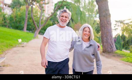 Ein paar ältere Frauen und Männer posieren zusammen in einem Park Stockfoto