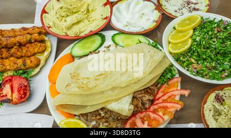 Traditionelle Gerichte des Nahen Ostens auf einem Tisch. Arabische Küche: Nahöstliches traditionelles Mittagessen. Verschiedene arabische orientalische Gerichte. Draufsicht, Nahaufnahme Stockfoto