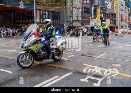 Melbourne, VIC, Australien. 30. November 2025. - Die Motorrad- und Fahrradoffiziere der Victoria Police schließen eine nasse Straße in der Stadt und leiten den Verkehr für eine Orgel Stockfoto