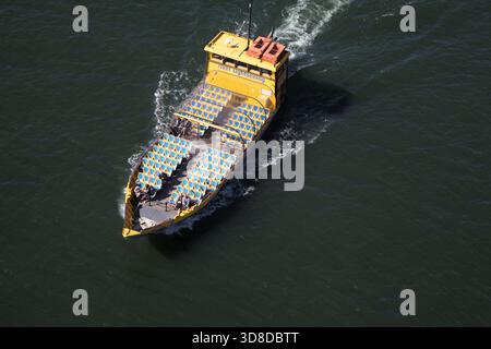 Porto, Portugal - 4. April 2017 - Ein gelbes Boot mit Sitzplätzen bringt Touristen an einem sonnigen Tag entlang des Flusses Douro in Porto Stockfoto