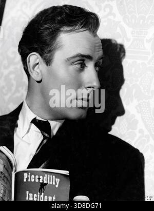 MICHAEL WILDING am Set mit dem freimütigen Porträt liest Filmausgabe Buch seines 1946 Film Piccadilly Incident während der Dreharbeiten von SPRING IN PARK LANE 1948 Regisseur HERBERT WILCOX Drehbuch Nicholas Phipps aus dem Roman Come Out of the Kitchen von Alice Duer Miller Musik Robert Farnon Miss Neagle's Dresses Kitty Foster Productions Herbert Wilcox und Anna Neagle Herbert Wilcox Productions / British Lion Film Corporation Stockfoto