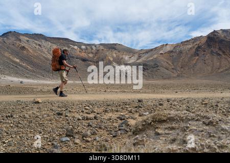 Wanderer über trockenen vulkanischen Kraterboden im Tongariro National Park, Neuseeland Stockfoto