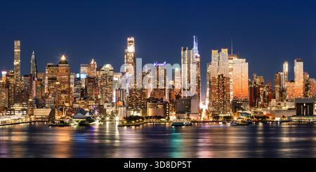 New York City erhöhter Nachtblick auf die Skyline von Midtown Manhattan, beleuchtete Wolkenkratzer und die Hafenpiers des Hudson River Park. USA Stockfoto