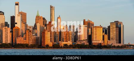 Blick auf die Skyline von Lower Manhattan bei Sonnenuntergang mit Wolkenkratzern mit Blick auf den Hudson River und den Battery Park. New York City, USA Stockfoto