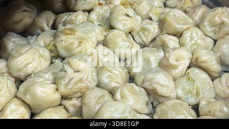 Heiße gedämpfte authentische Momos in Edelstahl-Dampfgarer im Straßenladen Stockfoto