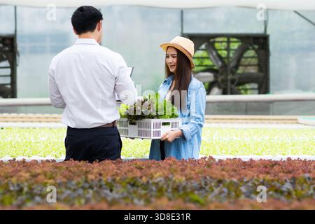 Asiatische Frau und Mann Farmer arbeiten zusammen in Bio-Hydrokultur-Salat-Gemüsefarm Stockfoto