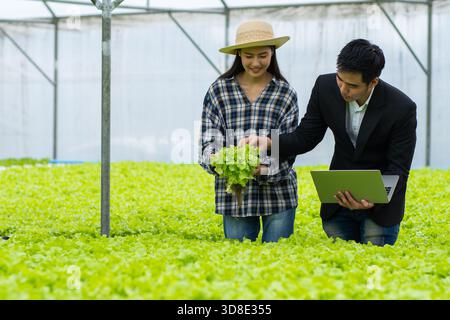 Asiatische Frau und Mann Farmer arbeiten zusammen in Bio-Hydrokultur-Salat-Gemüsefarm Stockfoto