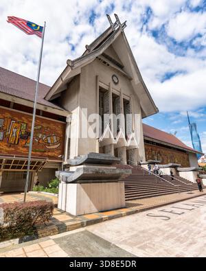 Muzium Negara, Eintritt zum Nationalmuseum in Kuala Lumpur, Malaysia. Mit malaysischer Flagge, traditioneller Architektur, Mosaikmalereien und Merdeka 118 Wolkenkratzer unter blauem Himmel. Stockfoto