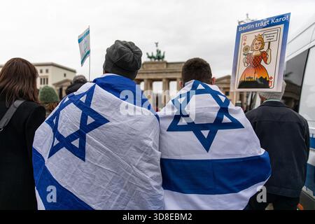 Berlin, Berlin, Deutschland. November 2025 30. An einem kalten, bewölkten Sonntag, dem 30. November 2025, versammelten sich pro-israelische Demonstranten auf dem Bebelplatz im Zentrum Berlins, bevor sie auf das Brandenburger Tor marschierten. Die Teilnehmer hielten israelische Fahnen und Schilder, die den zunehmenden Antisemitismus in Deutschland verurteilten. Rabbiner Yehuda Teichtal von Chabad Berlin und Politikerin Karoline Preisler nahmen an der Kundgebung teil, sprachen mit den Teilnehmern und drängten auf öffentliche Solidarität mit den jüdischen Gemeinden. Quelle: ZUMA Press, Inc./Alamy Live News Stockfoto