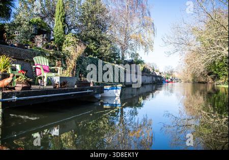 Ein Wohnanleger am Fluss Lea am Enfield Lock, mit Pflanzcontainern und Gartenmöbeln in ruhiger Lage am Wasser Stockfoto