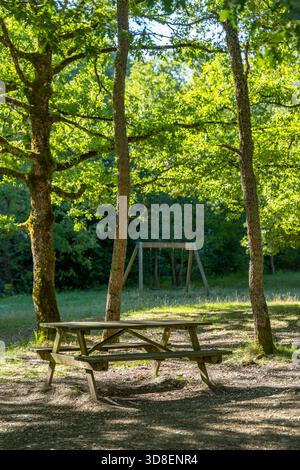 Picknicktisch aus Holz und Schaukeln in einem ruhigen Park in Sellano, Umbrien, Italien Stockfoto