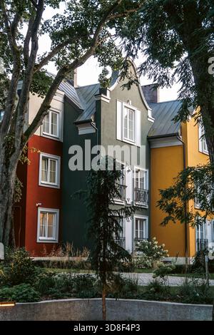 Farbenfrohe urbane Szene, ruhige Nachbarschaftsszene mit lebhaften Fassaden und natürlichem Schatten, friedliche Stadtlandschaft mit lebendig bemalten Häusern Stockfoto