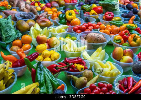 Eine lebendige Präsentation von verschiedenen Obst- und Gemüsesorten in durchsichtigen Kunststoffbehältern auf einem Markt Stockfoto
