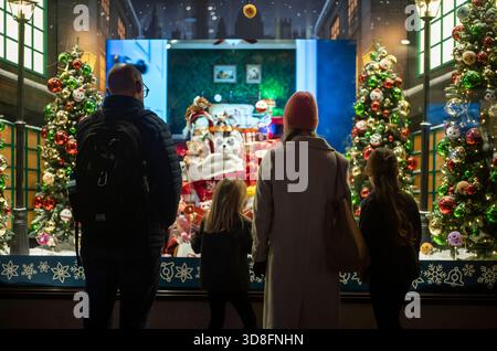 Ein Familienblick auf das Hamleys Christmas Window Display in der Regent Street, während der Bauarbeiten bis zur Festsaison 2025 im Zentrum von London, England, Großbritannien Stockfoto