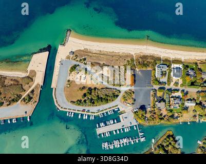 Blick aus der Vogelperspektive auf den Strand mit klarem Wasser und den Yachthafen am Löwenkopf Stockfoto